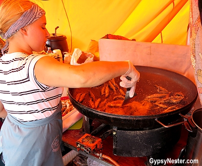 Stirring up muikku vendace, whole fried fish, in an outdoor market in Helsinki, Finland