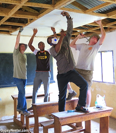 The first ceiling tile of our classroom renovation in Tanzania, Africa with Discover Corps!