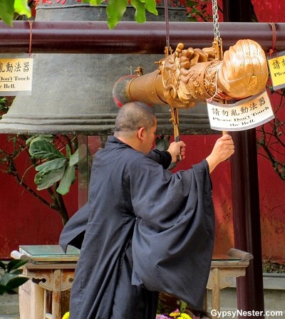 A monk rings a bell at the Big Buddha's monestary in Hong Kong, China