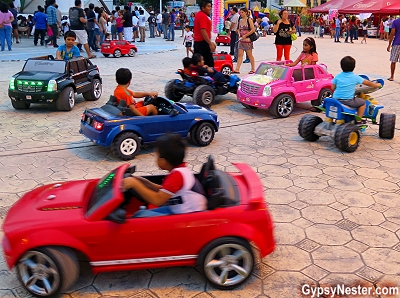 Kids driving electric cars at Parque de las Palapas in Cancun, Mexico