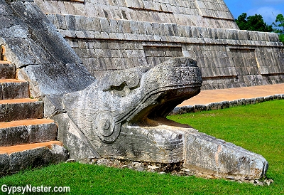The carved stone heads of Kukulkan at the base of the pyramid of Chichen Itza in Mexico