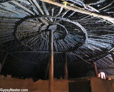 The ceiling of a inkajijik hut of Massai people in the Great Rift Valley in Tanzania, Africa with Discover Corps. The construction is mostly wooden, large support poles hold up a thatched roof, with walls made of branches plastered over with adobe-like cement made from dirt, urine, cow dung, and ashes