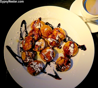 poffertjes, little fluffy pancakes with chocolate sauce and powdered sugar in Amsterdam