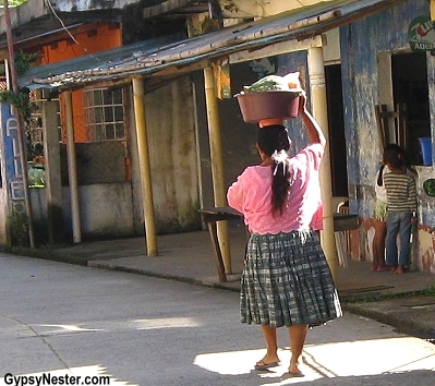 Woman carrying goods atop her head in Livingston, Gualemala