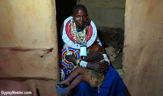 A Maasai woman and child in a traditional hut in the Great Rift Valley, Tanzania, Africa