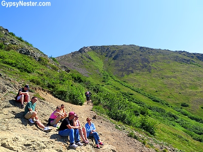 People resting and enjoying the view on the way up to the top of Flat Top Mountain in Anchorage, Alaska