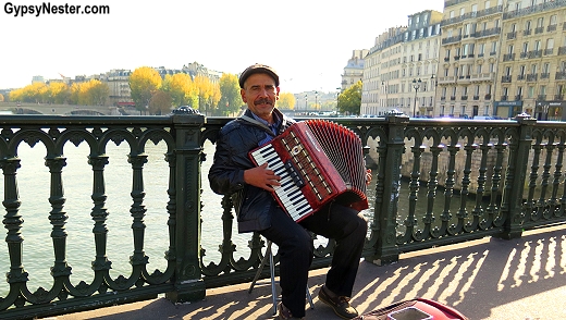 Man plays accordian on a bridge in Paris, France