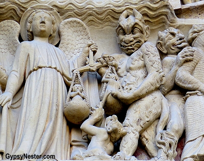 Close up detail of the devil on the facade of Notre Dame Cathedral in Paris, France