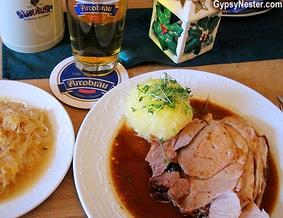 Ofenfrischer Schweinsbraten mit Kruste, dazu Knödel und Kraut, which translates exactly to: Oven Fresh pork roast with crust, with dumplings and sauerkraut in Passau, Germany