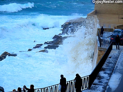 Waves crashing against the sea wall in Siracusa, Sicily, Italy