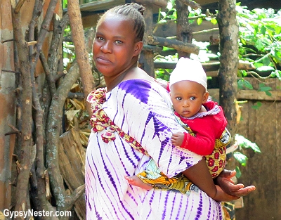 A Chagga woman carries her baby on her back in Tanzania, Africa. With Discover Corps