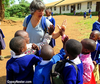 Our students in Africa run out to meet Margaret before class. With Discover Corps.