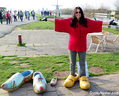 Veronica tries on wooden shoes in Kinderdijk, Holland, The Netherlands - GypsyNester.com