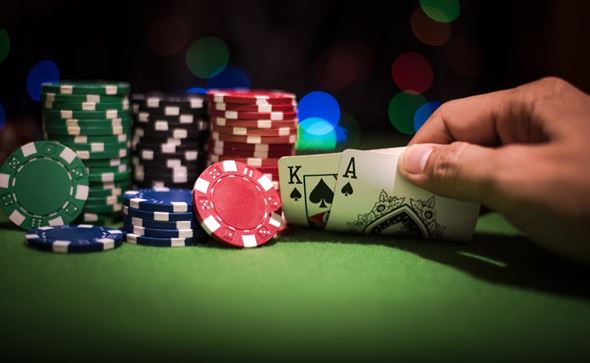 Hands holding cards at the poker table